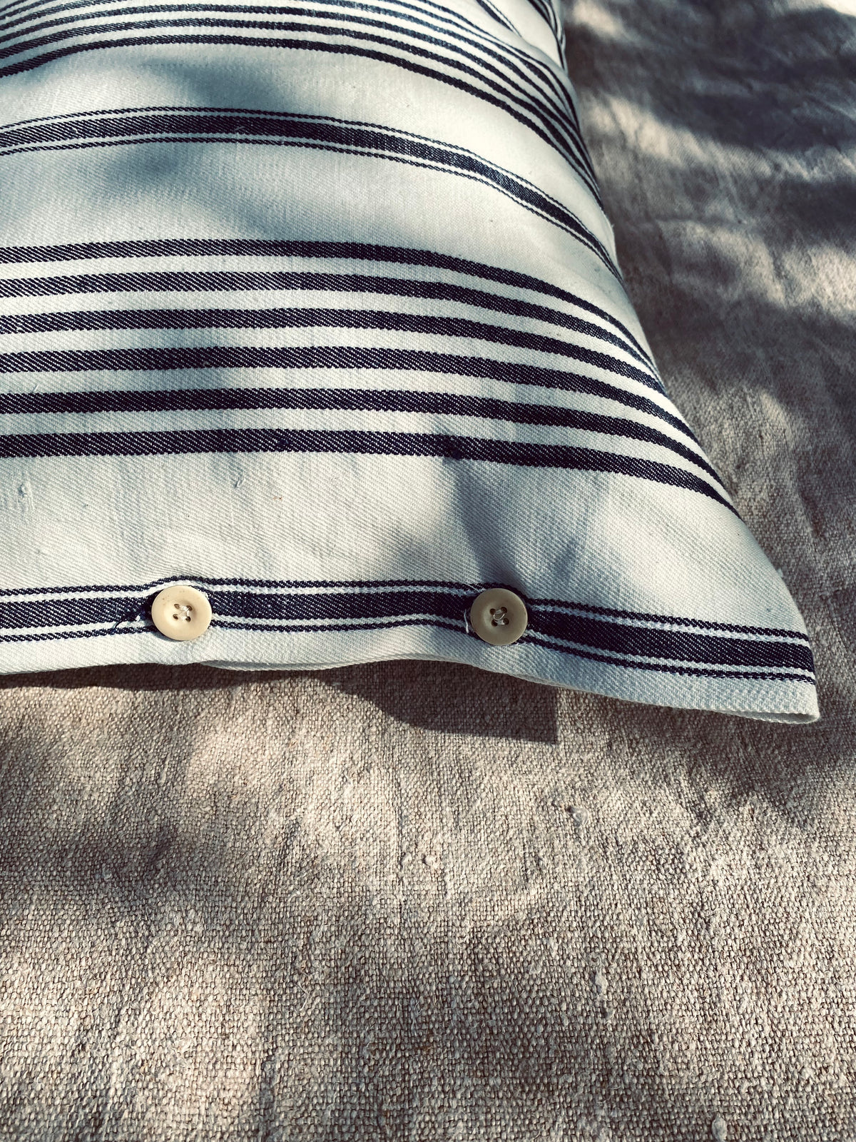Le coussin à rayures bleues et blanches