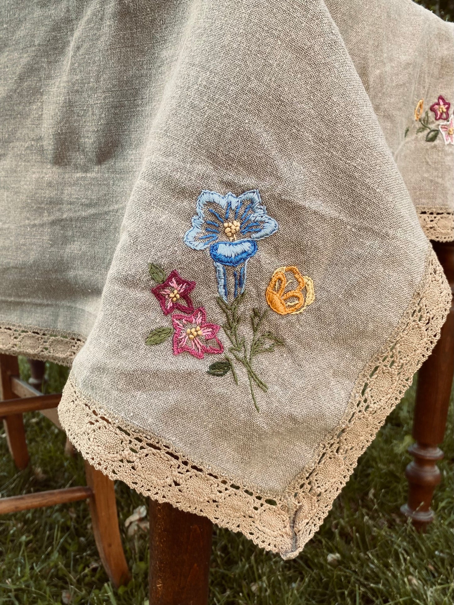 La vieille nappe en lin brodée de fleurs et de dentelle