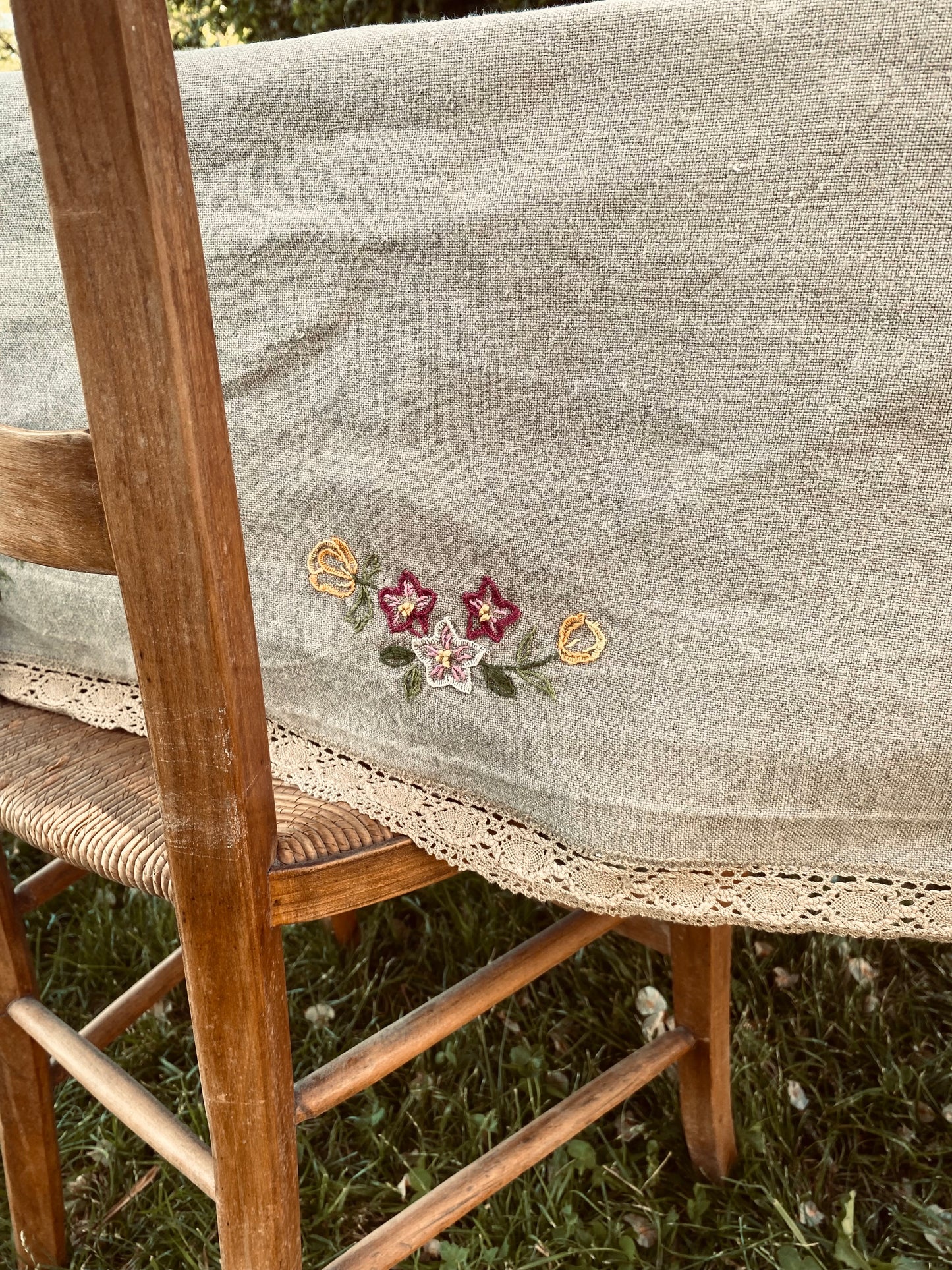 La vieille nappe en lin brodée de fleurs et de dentelle