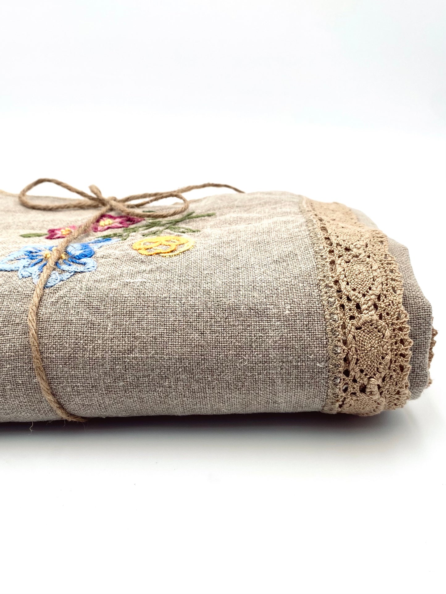 La vieille nappe en lin brodée de fleurs et de dentelle