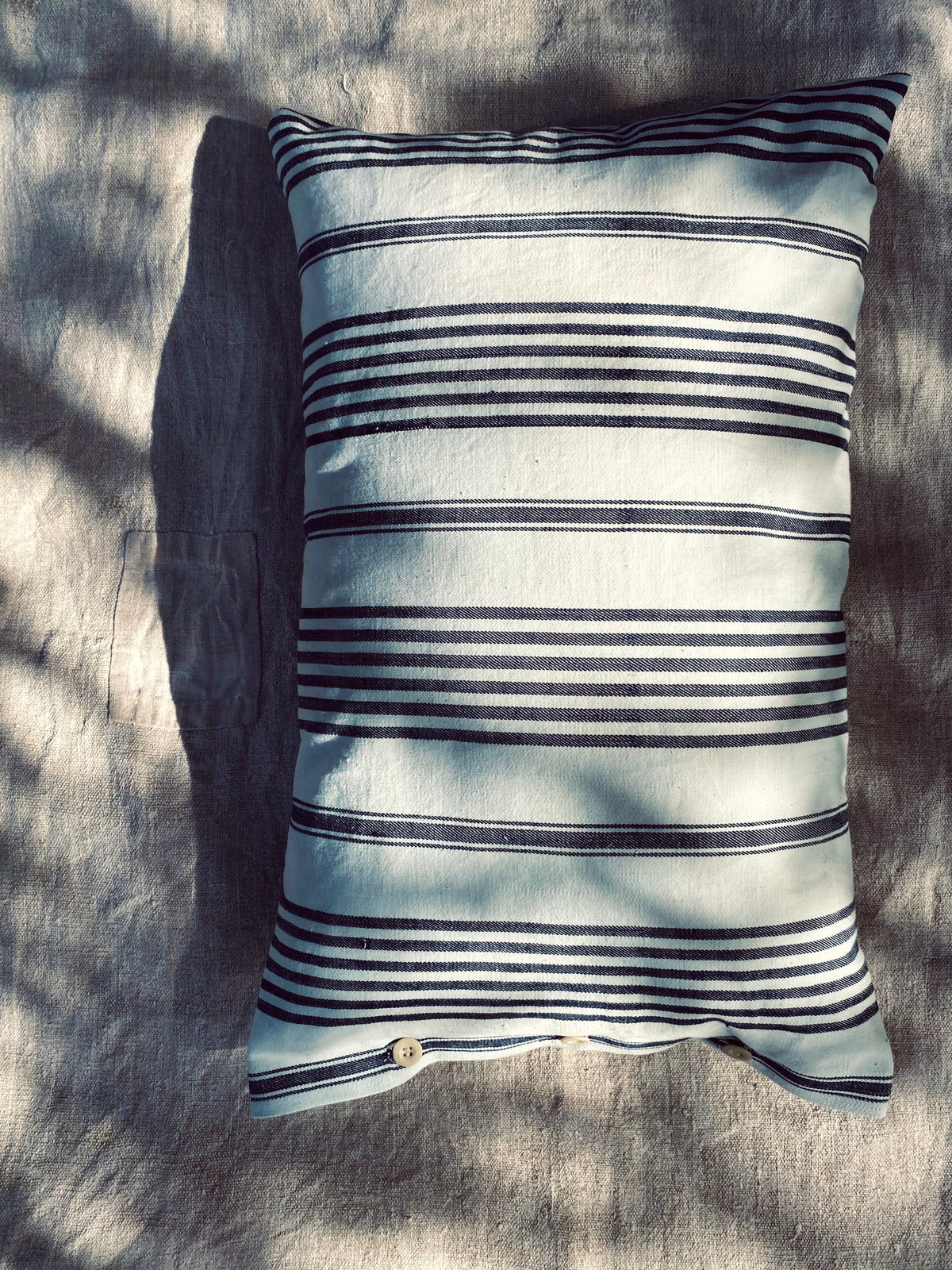 Le coussin à rayures bleues et blanches