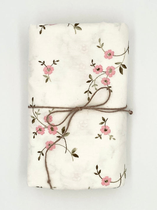 La nappe avec des fleurs roses